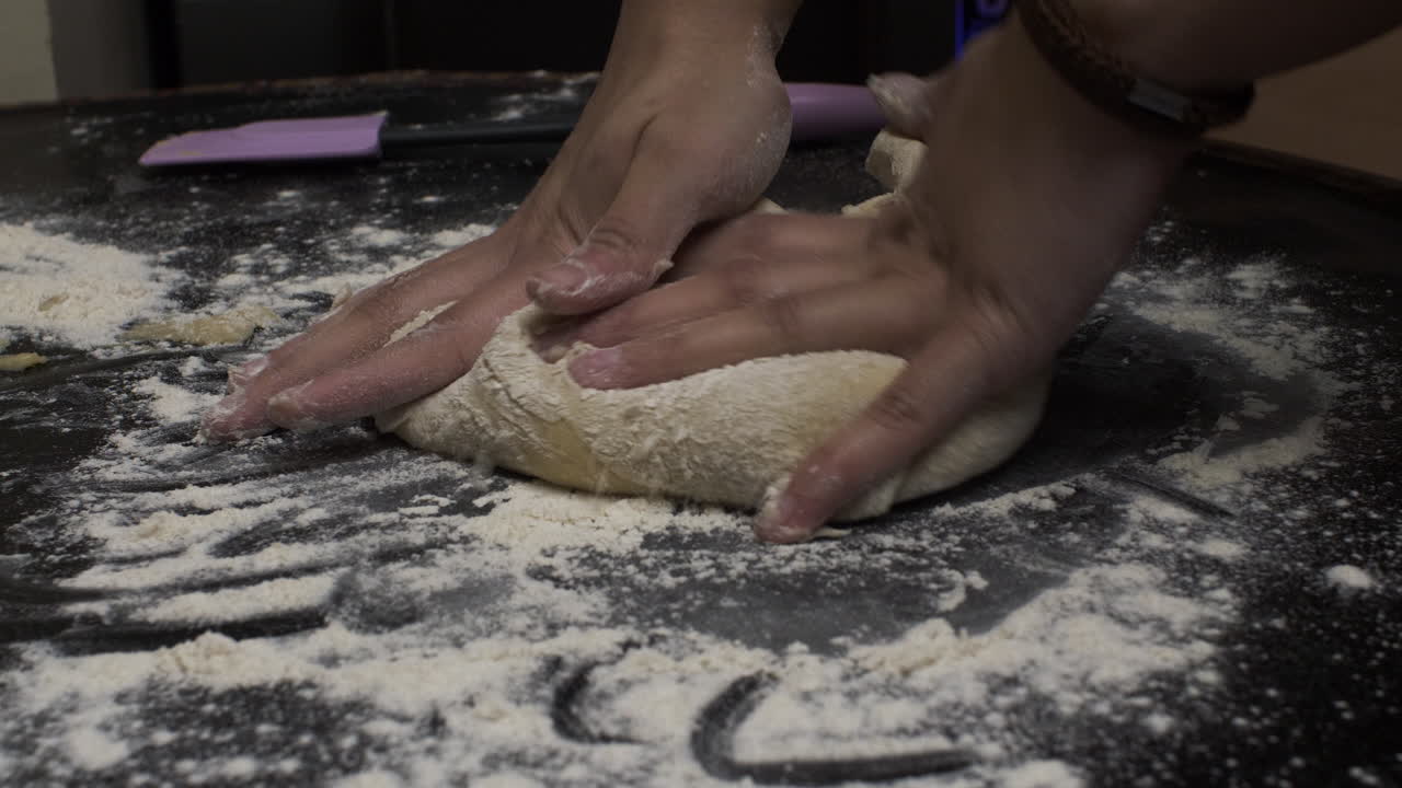 Female Hands Kneading Dough In Flour On Table