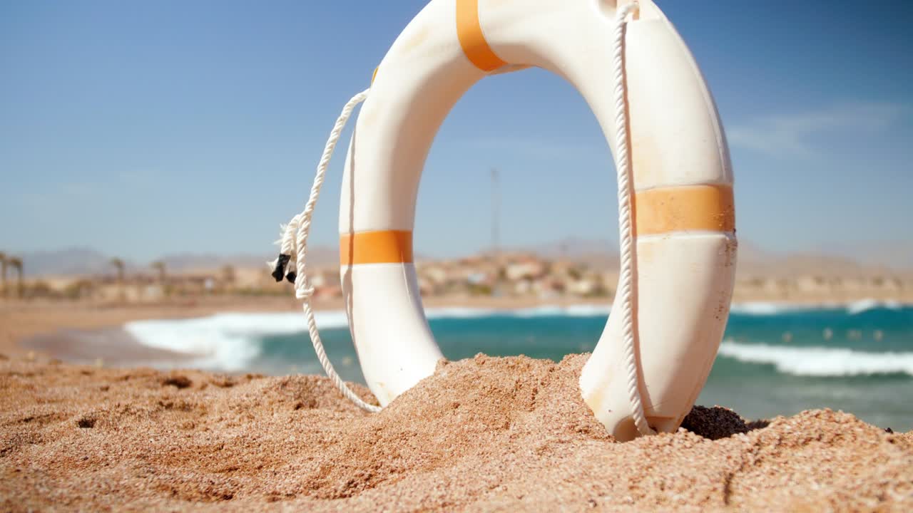 un hermoso video en cámara lenta de 4k de una boya de anillo salvavidas excavada en la arena de la playa