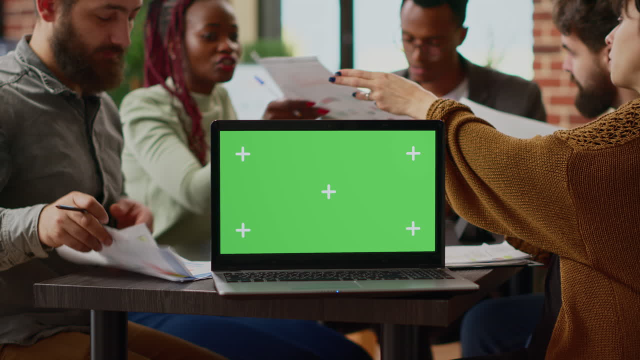 Business people working with paperwork and greenscreen on laptop