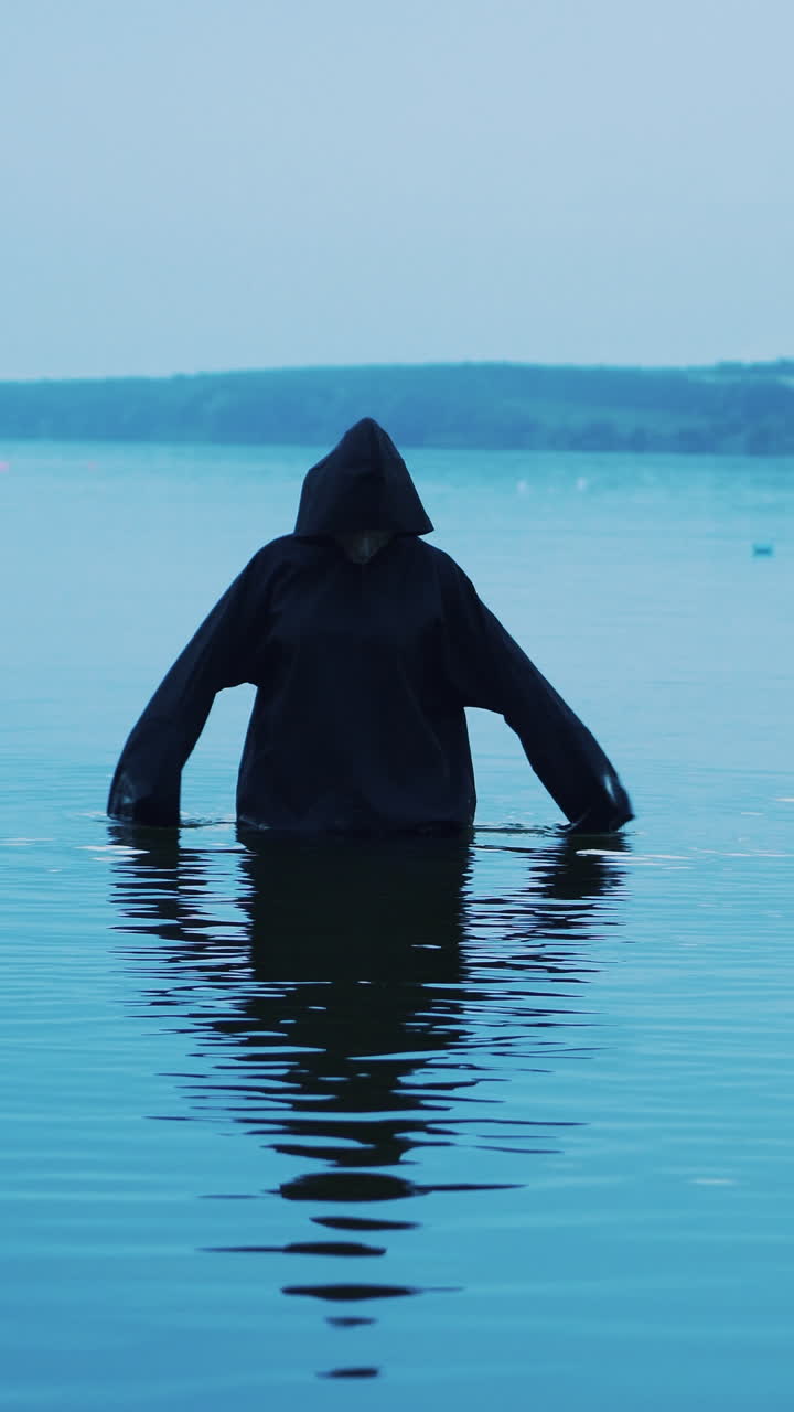 Scary figure in black mantle. Halloween costume Vertical video