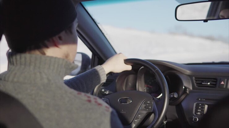 Persona alla guida di un'auto in inverno