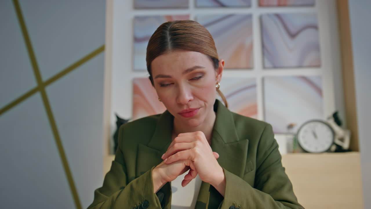 Sad businesswoman nodding online conversation in private work space pov view