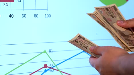 4k sostiene una moneda japonesa, datos fondo blanco, un espacio de copia, contar un dinero