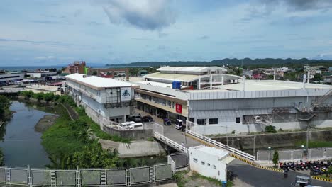 establishing drone shot of occupied parking lot and small river alongside virac town center, catanduanes