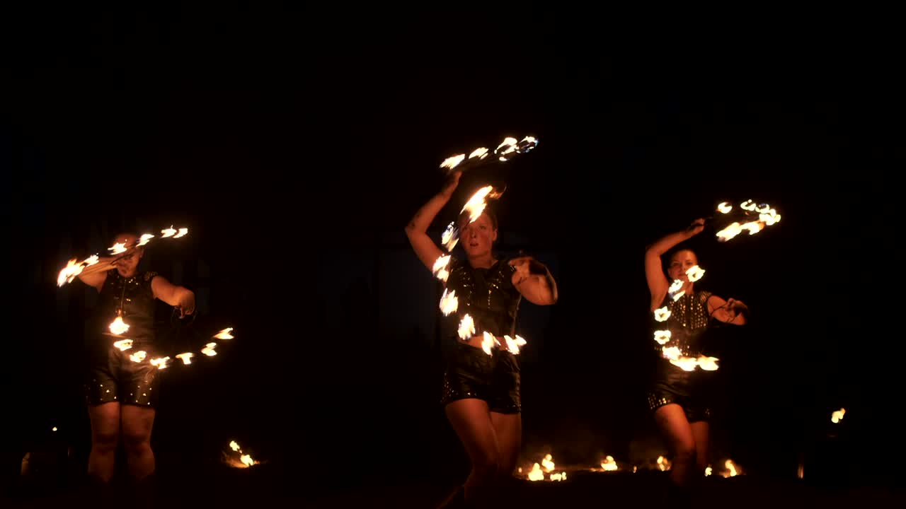 cámara lenta: actuación de fuego profesional tres mujeres con antorchas y un hombre con lanzallamas