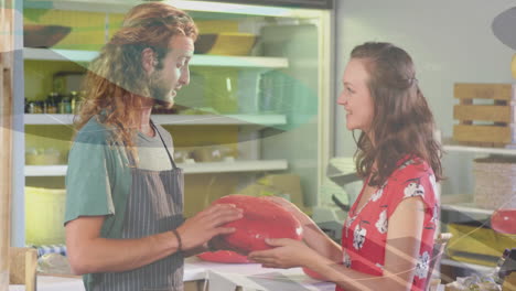 geometric shapes animation over two people exchanging red object in store