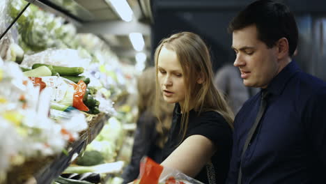 man and woman buying fresh vegetables in grocery