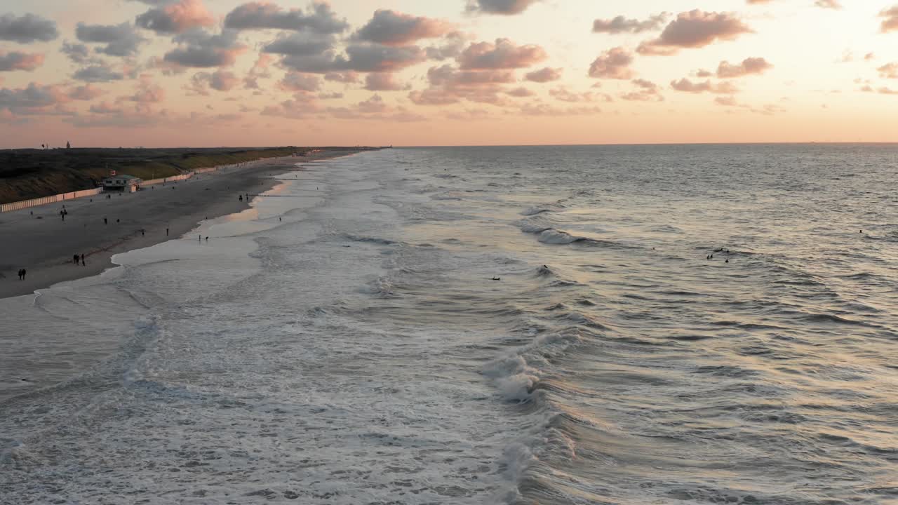 Surfisti di fronte alla città turistica di Domburg nei Paesi Bassi al tramonto.