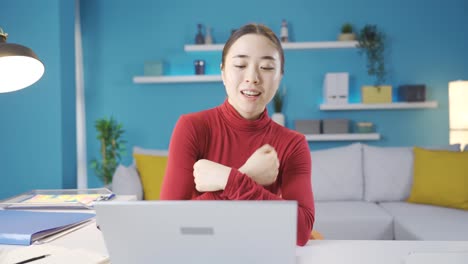 Happy-Asian-woman-starts-dancing-at-the-table.