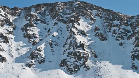 aerial view of jagged snow-dusted peaks under a clear blue sky in arapahoe basin, colorado