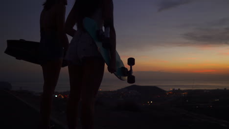 enjoying the mountain's summit after skateboarding, friends gaze at the beautiful sunset