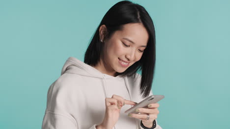 스마트폰을 스크롤하는 아시아 여성.