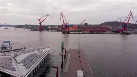 Aerial-drone-view-of-small-docked-passenger-ferry-at-harbor-area-in-Gothenburg,-Sweden