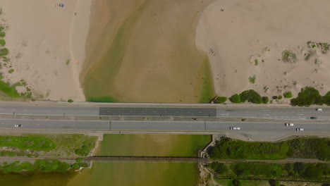 Top-down-footage-of-multilane-road-passing-on-bridge-over-river.-Parallelly-leading-railway-track.-South-Africa