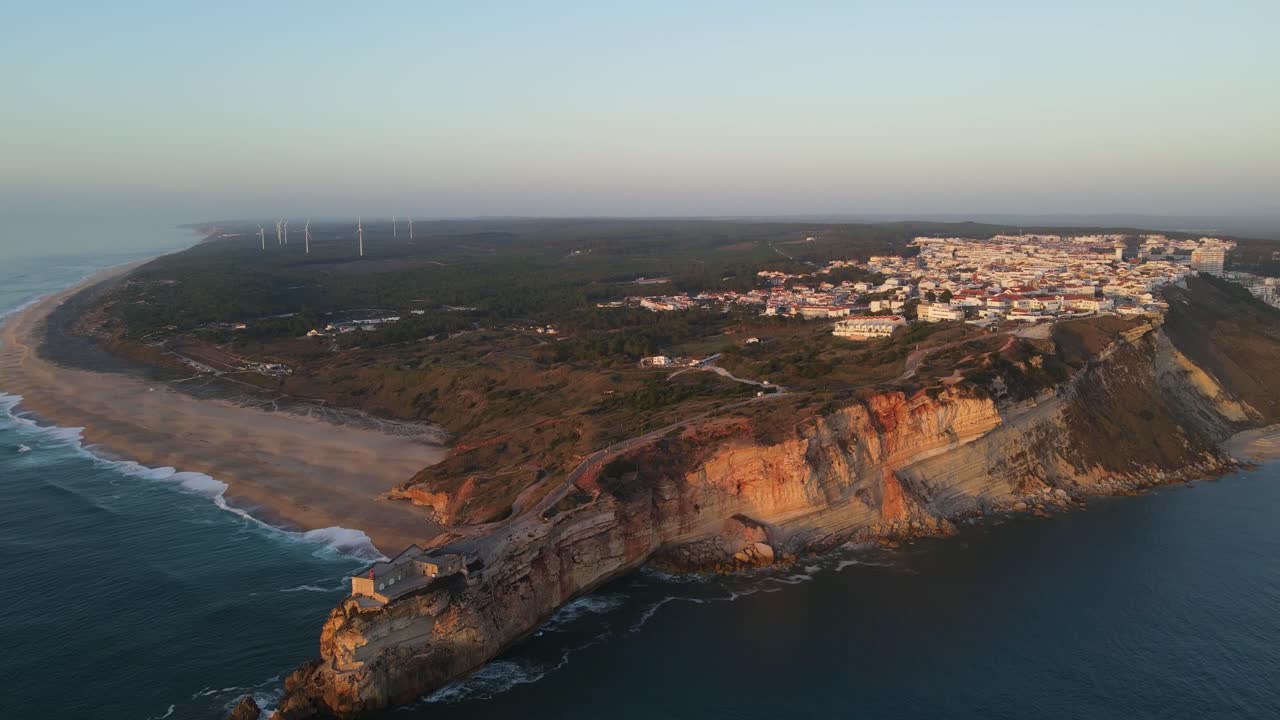 Nazare cliffs and city at sunset