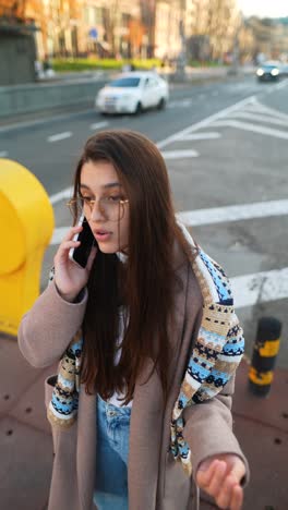 una mujer joven en la calle hablando por teléfono.