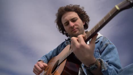 a young caucasian boy plays the guitar.