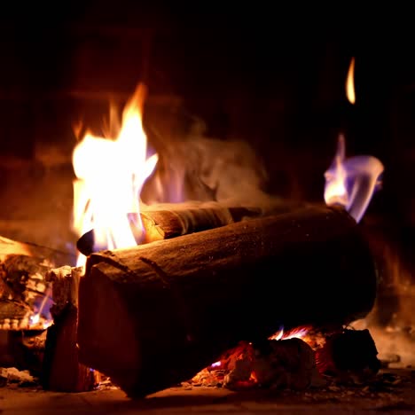 warmth and comfort at home in cold season. fire and smoke over wooden logs in fireplace. wood burning in a stone fireplace. close-up
