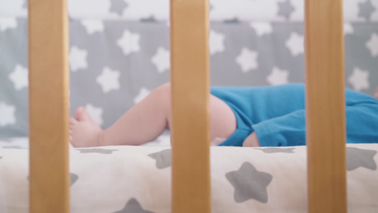 neonato in bodysuit azzurro poggia su tessuto con stella