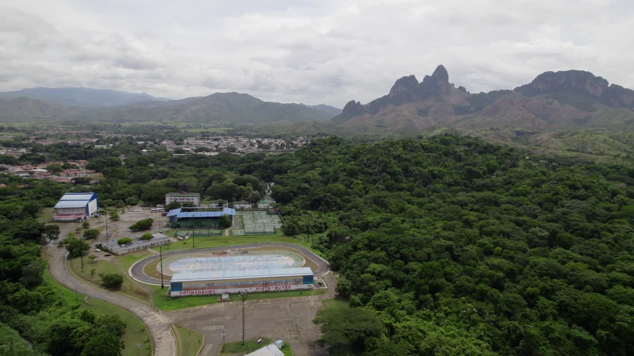 Stunning bird's eye view capturing San Juan de Los Morros valley, showcasing the city, green residential areas, sports center, and limestone monoliths