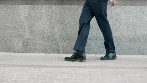 hombre de negocios piernas bailando en la calle. zapatos de primer plano bailando al aire libre cerca del edificio