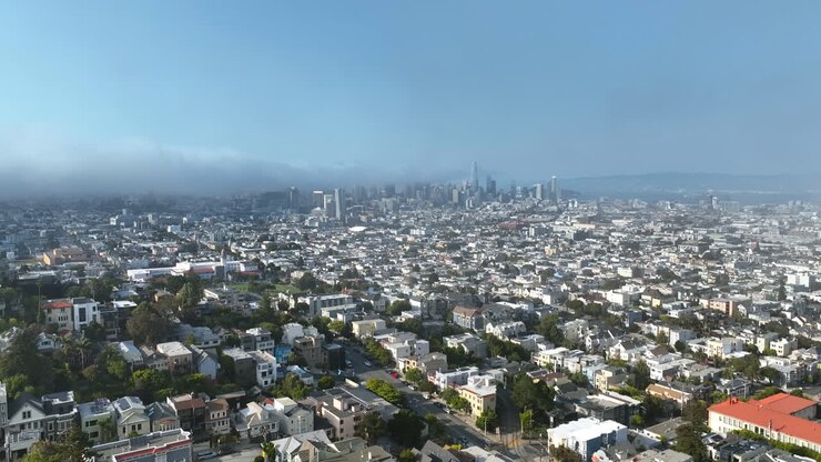 Vista aerea all'indietro attraverso la nebbia e sopra il paesaggio urbano di San Francisco. Giornata di sole