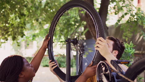 couple reattach bicycle wheel outside