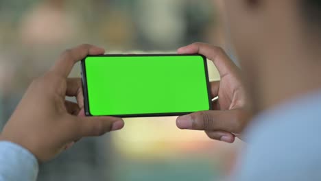 rear view of african man looking at smartphone with chroma screen