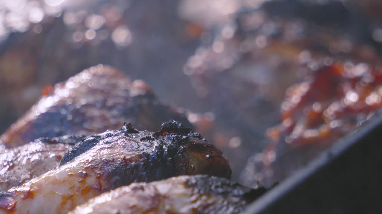 Chicken Drumsticks Cooking on BBQ Grill as Smoke Covers Grill and Different Meats. Outdoor Summer Cooking with Fresh High Protein Ingredients. Delicious and Tasty Street Food.
