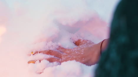 Mano-De-Mujer-Con-Manicura-Sumergida-En-Nieve-Cerca-Del-Fuego-Ardiente