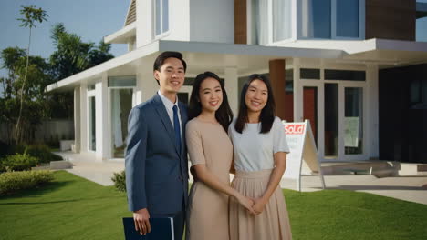 Happy family in front of their new sold home