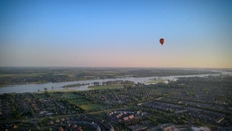 Colorful-hot-air-balloon-flying-over-buildings-in-small-european-city-in-4k-at-summer-sunset,-aerial-view,-Gorinchem,-region,-Netherlands