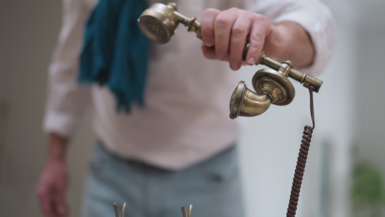 중요한 전화를 하기 위해 번호를 다이얼하는 남자: 아트 스튜디오에서 오래된 세계 미학과 현대적인 통신의 독특한 혼합물.