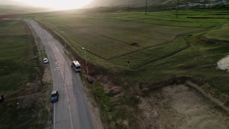 Vista-Aérea-De-La-Manada-De-Vacas-Al-Cruzar-La-Carretera-Durante-La-Puesta-De-Sol