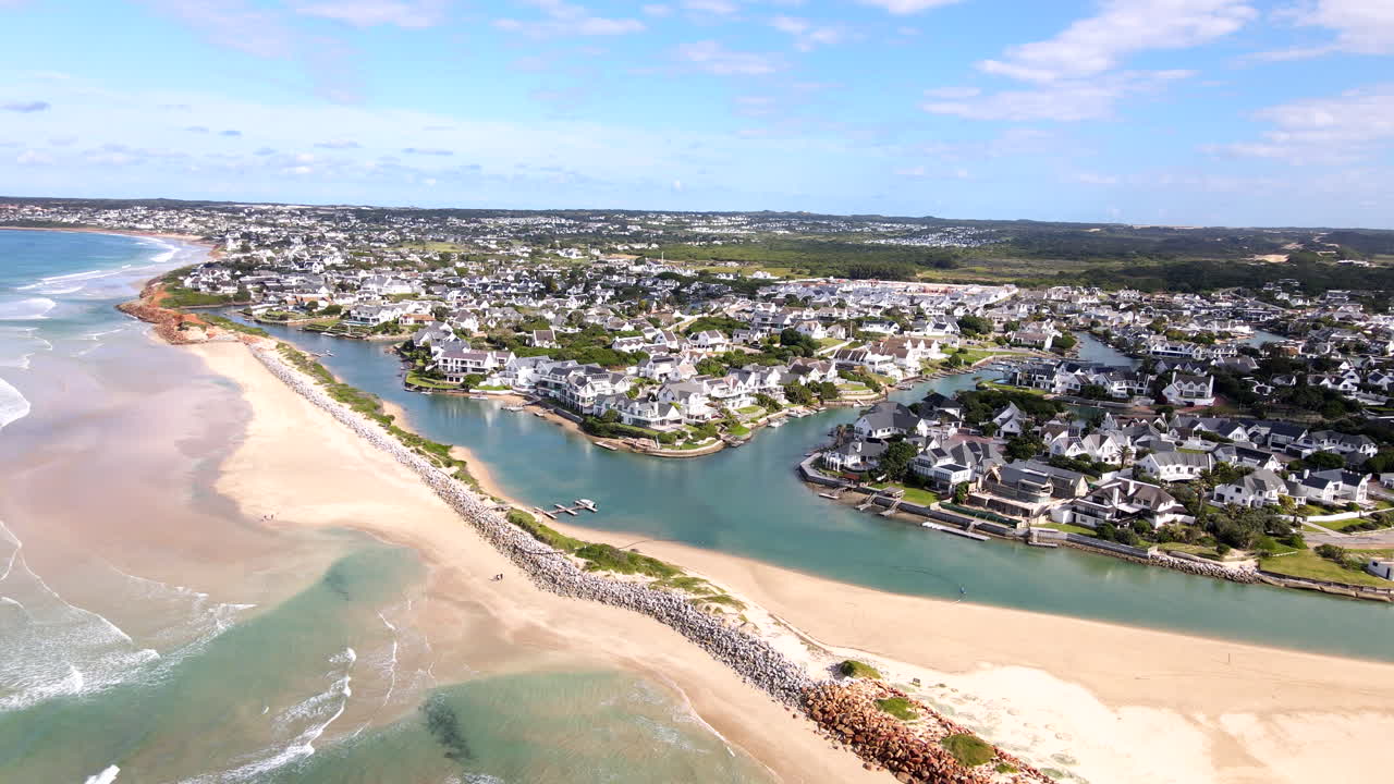 Drone pullback reveals breakwater and beach protecting exclusive St Francis Bay