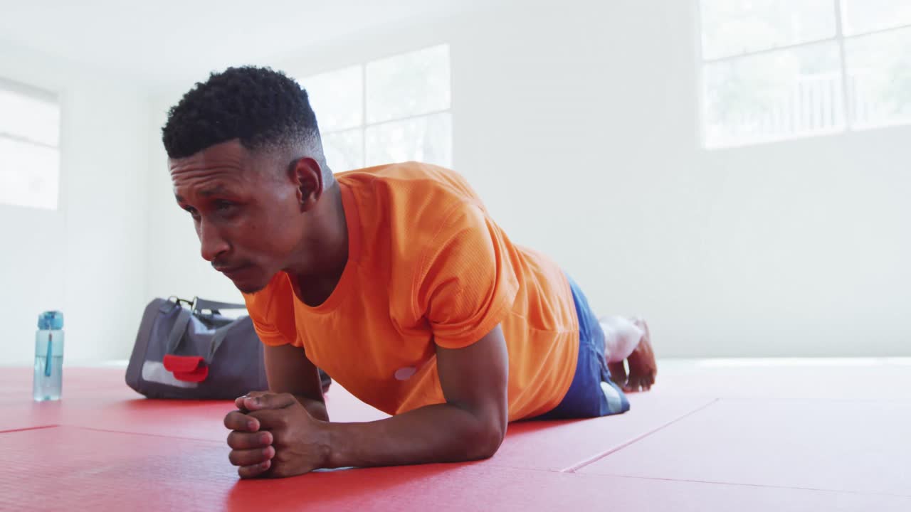 Uomo di etnia mista che fa stretching su un tappeto