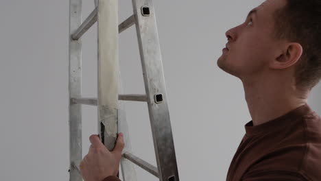 man carrying a ladder and removing tape