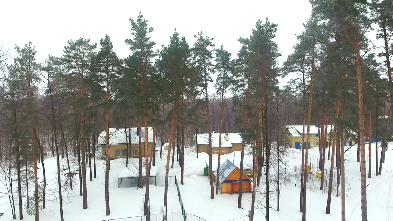 взгляд с воздуха на гостиничный клуб здоровья в заснеженном лесу в зимнее время