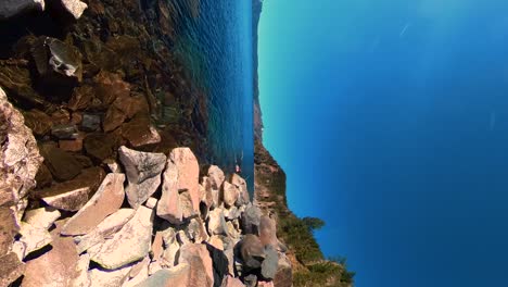 A-red-haired-man-swimming-on-the-edge-of-Crater-Lake-National-Park