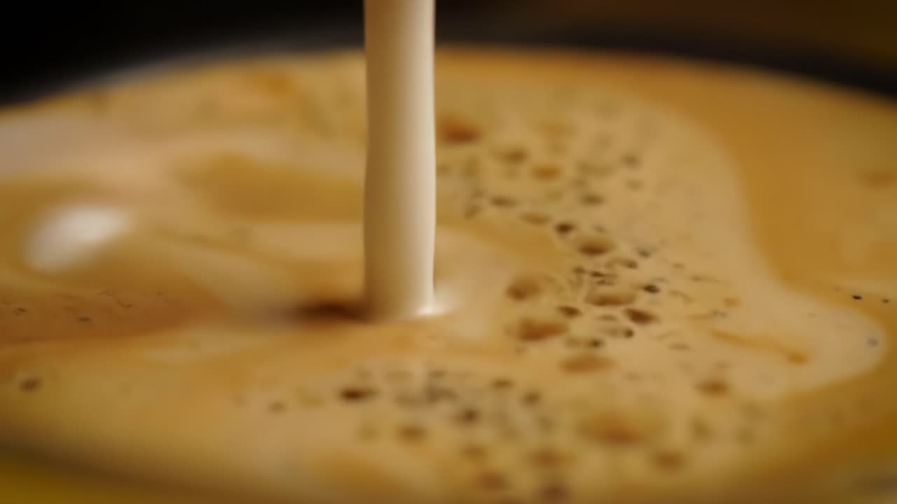 An Enchanting Dance of Cream and Coffee: Visualizing the Irresistible Marbling of Milk in Dark Brew as it Combines to Create a Delicious, Creamy Swirl