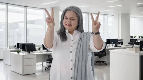 happy indian senior businesswoman showing victory sign