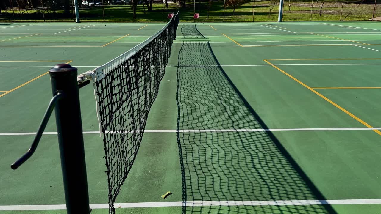 Tennis court closeup net winder down line of multiple courts Perth Australia