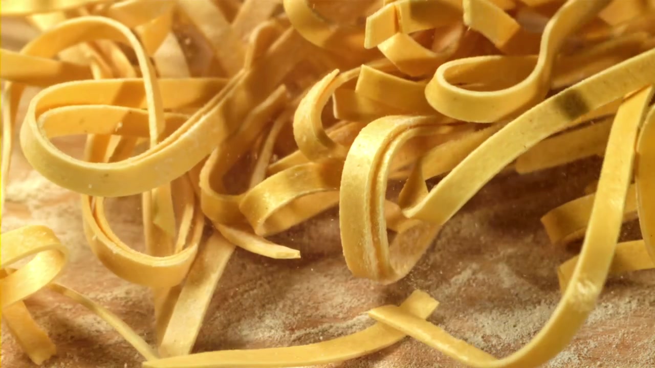 Pasta Fresca che Cade su un Tagliere di Legno Infarinato al Rallentatore