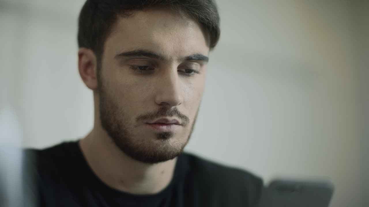 Joven mirando su teléfono. Retrato de un empresario leyendo su móvil.