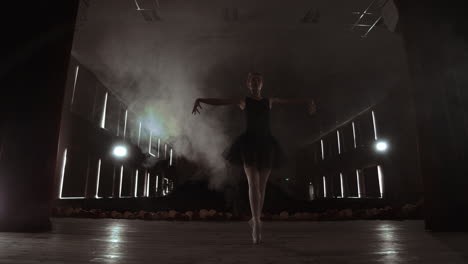 young professional ballerina making circular movements on stage. beautiful girl dancing in spotlights in evening during dress rehearsal.