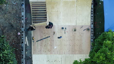 Two-men-building-a-skate-ramp-together-in-a-backyard