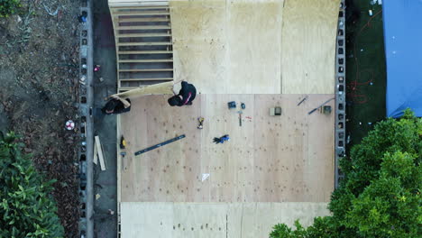 two men building a skate ramp together in a backyard