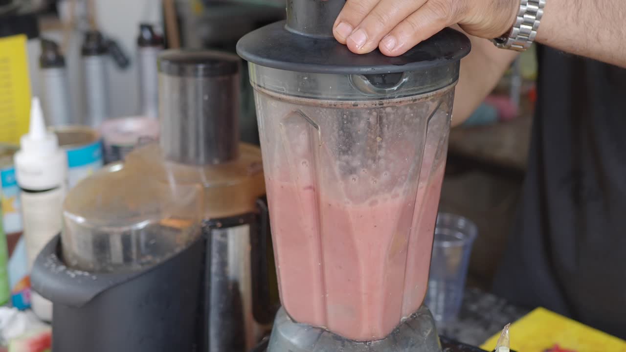 Person blending a smoothie in a blender