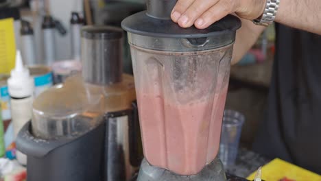 person blending a smoothie in a blender