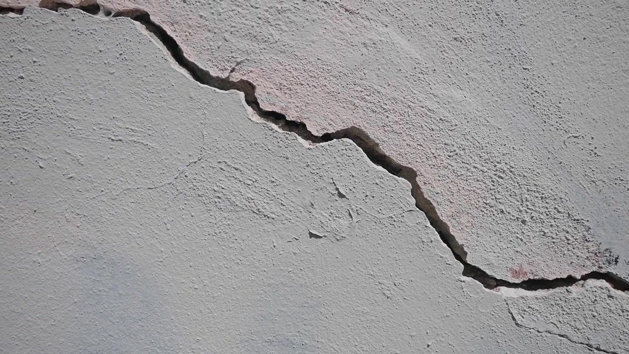 Textured White Wall with a Large Diagonal Crack